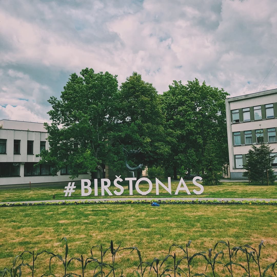 En skylt med ortsnamnet Birštonas framför stadsmiljön